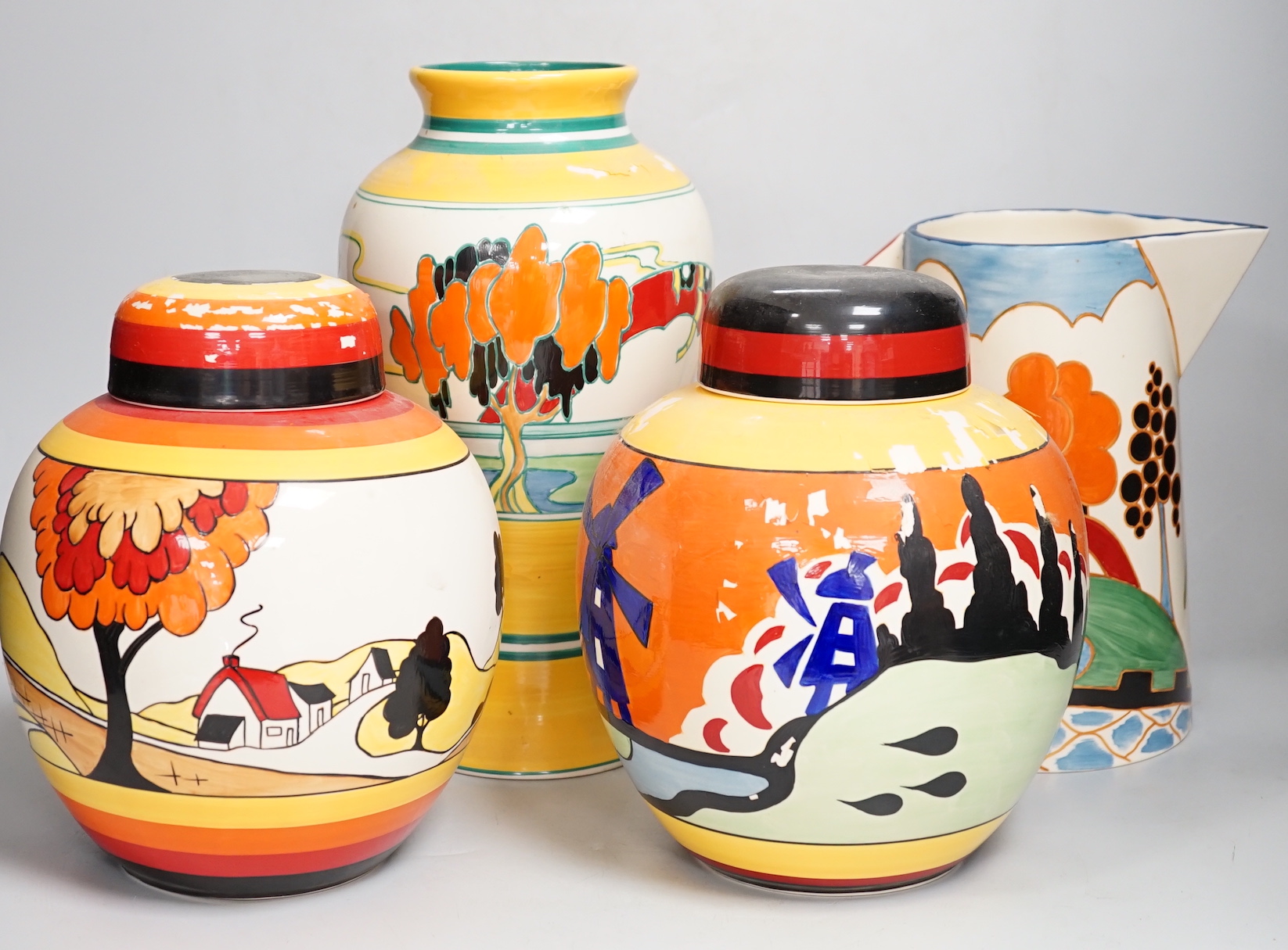 Two Clarice Cliff reproduction Bizarre designed jars, a vase and a jug (decoration a.f.), tallest vase 30cm high